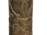 a brass vase with a bird on it on a white background