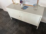 a white cabinet with a glass vase on top of it
