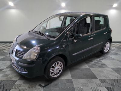 une photo d'une petite voiture verte garée dans un garage