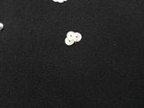 two buttons that are on a black cloth