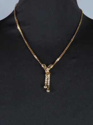 un collier en or muni d'une chaîne qui y est attachée