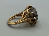 an image of a gold ring with a black stone on it