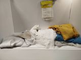 a pile of clothes sitting on a shelf in a bathroom