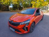 une voiture rouge garée sur un parking, avec des arbres en arrière-plan