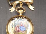 a gold pocket watch with a picture of a woman on it