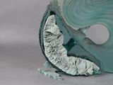 a sculpture of a man riding a wave on a surfboard