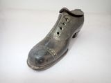a silver shoe that is sitting on a white surface