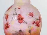 a glass vase with flowers painted on it on a table
