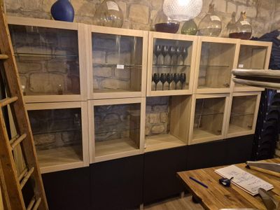 une pièce avec de nombreuses étagères en verre et une table en bois