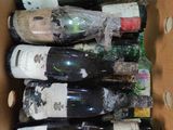 many bottles of wine in a cardboard box on the floor