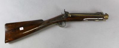 un fusil avec un canon en bois et des garnitures en laiton sur fond blanc