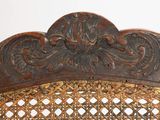 carvings on the back of a wicker chair are intricately carved