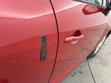 a close up of a red car door with a sticker on it