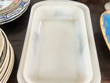a table with plates and bowls on it and a vase on the table