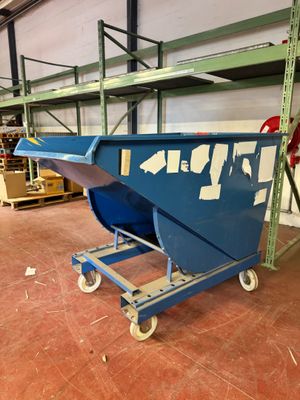 une benne bleue posée sur un chariot dans un entrepôt