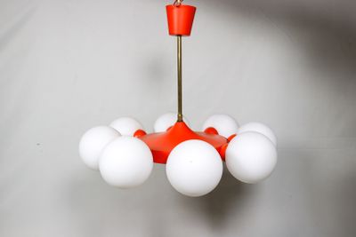 un lustre rouge et blanc auquel sont suspendues des boules blanches
