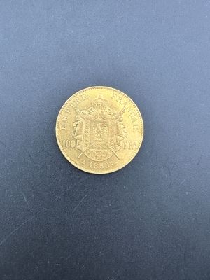 gros plan d'une pièce d'or sur une surface noire