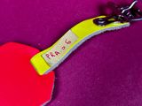 a heart shaped keychain with a tag attached to it
