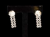 a close up of a pair of earrings on a stand