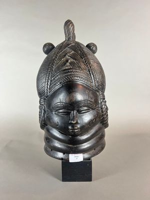 une sculpture noire représentant la tête d'une femme, posée sur un socle noir