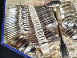 a lot of silver spoons and spoons in a box