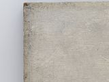 an old book sitting on top of a table next to a white wall