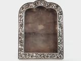 an antique silver picture frame with a floral design
