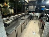 une grande cuisine avec des plans de travail et des appareils électroménagers en inox