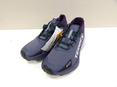 the purple and black running shoes are on a white surface