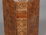 un vieux livre à la couverture brune posé sur une table