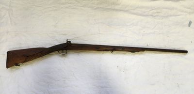 un fusil posé sur un drap blanc