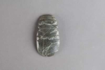 une image représentant un objet en pierre verte posé sur une surface blanche