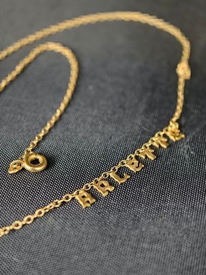 gros plan d'un collier en or sur une surface noire