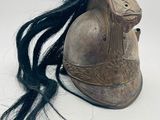 un casque sur lequel on distingue de longs cheveux noirs sur un fond blanc