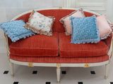 a red couch with many pillows on it in a room