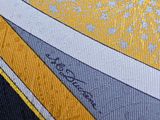 a close up of a tie with a yellow and gray design