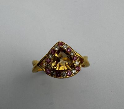 un gros plan d'une bague sertie d'un diamant jaune et de saphirs roses