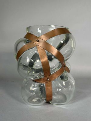 un vase en verre entouré d'une lanière en cuir