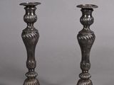 pair of antique silver candlesticks on a grey background