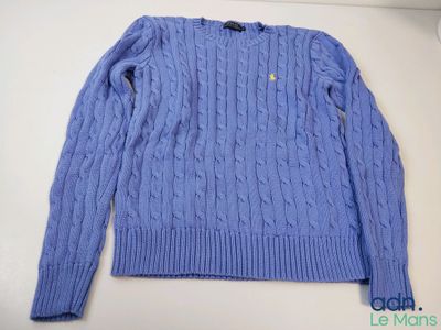 un gros plan d'un pull bleu posé sur une table blanche