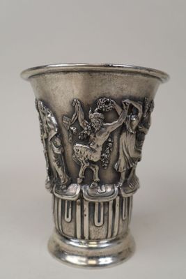 un vase en argent orné d'un motif, posé sur une table