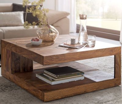a coffee table with books and a vase on it