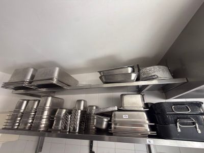 many pots and pans on the shelves in the kitchen