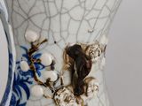 a vase with a bird on it sitting on a table