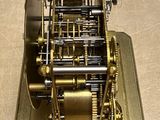 a gold clock that is on display on a table