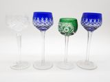 quatre verres à vin sont alignés sur une surface blanche