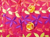 purple and orange jacket with gold buttons on a red background