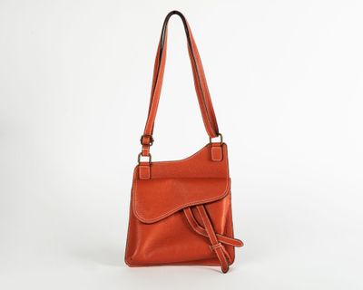 an orange leather handbag on a white background