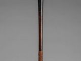 a large wooden stick with a metal handle on a stand