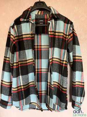 a close up of a shirt hanging on a hanger on a wall